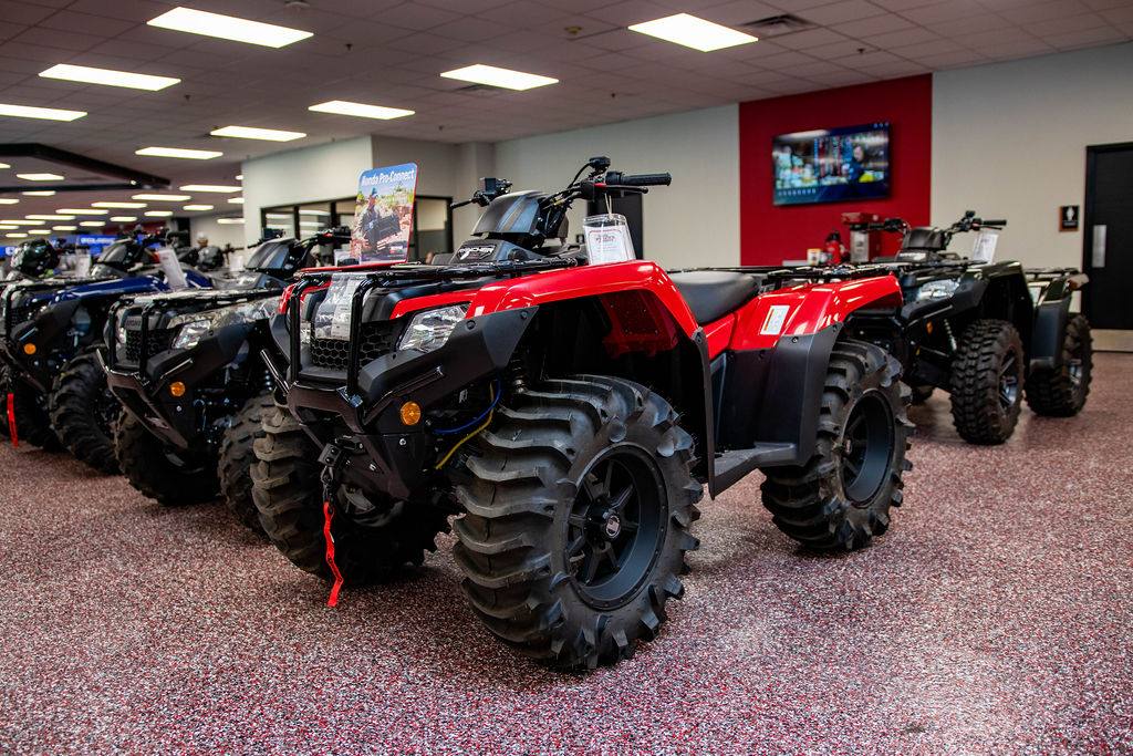 Honda ATVs lined up on the Friendly Powersports showroom floor